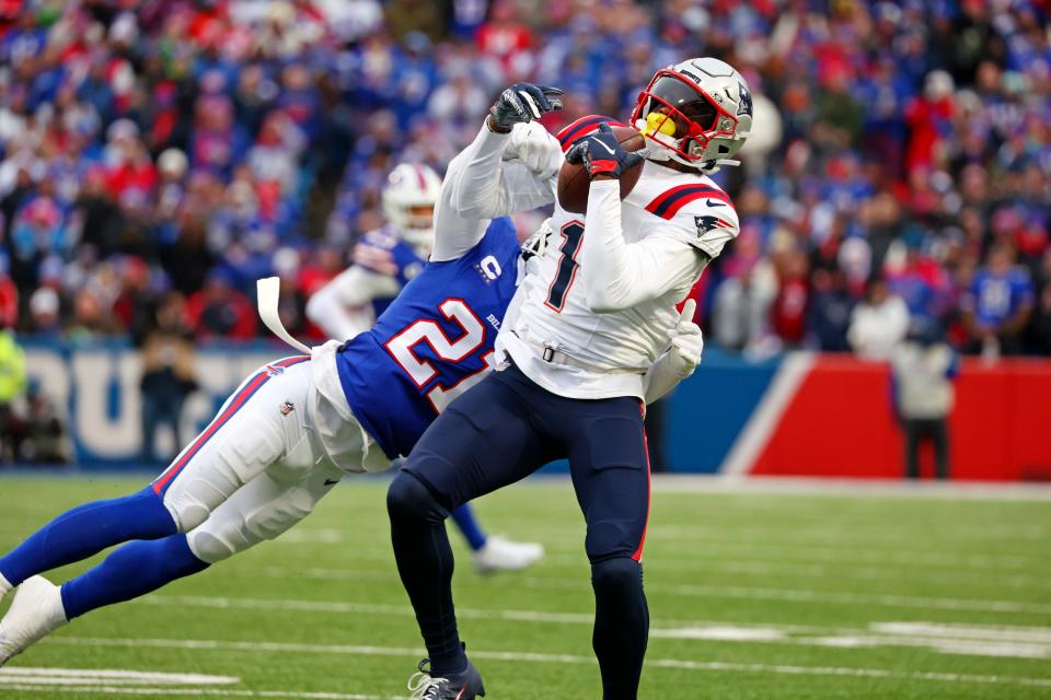 New England Patriots wide receiver DeVante Parker (1) makes a catch for a first down with Buffalo Bills safety Jordan Poyer (21) defending during the first half of an NFL football game in Orchard Park, N.Y., Sunday, Dec. 31, 2023.