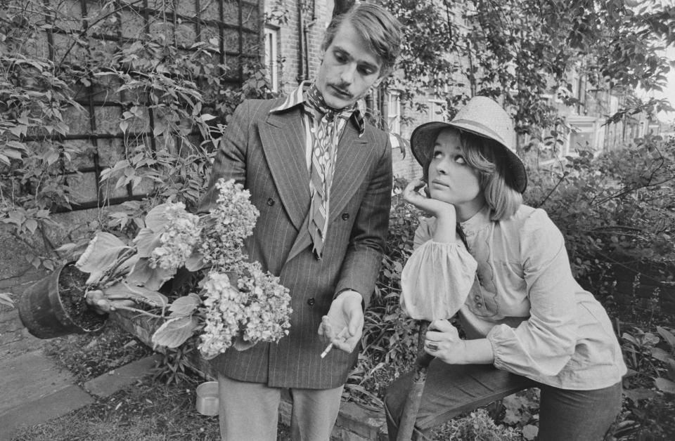 English actor Jeremy Irons and his partner, Irish actress Sinead Cusack, examine a wilted hydrangea in the garden of their new home in Hampstead, London, UK, 28th May 1974.  (Photo by Evening Standard/Hulton Archive/Getty Images)