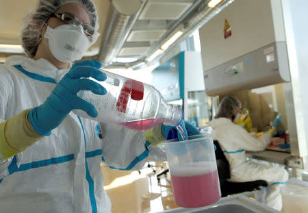 FILE PHOTO: A lab assistant performs an experiment during an inauguration visit of a new P3 level research laboratory against tuberculosis at the School of Life Sciences of the Swiss Federal Institute of Technology (EPFL) near Lausanne, Switzerland March 17, 2010. REUTERS/Denis Balibouse /File Photo