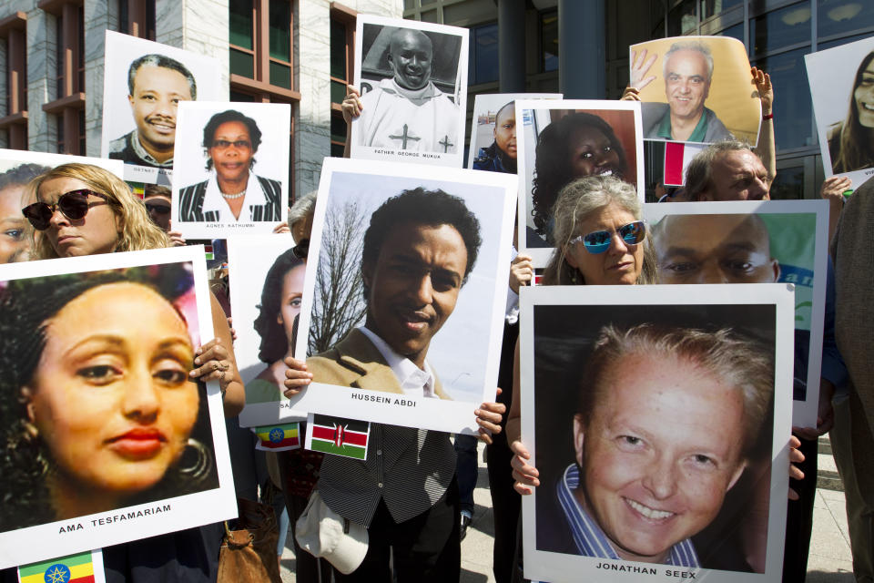 Demonstrators hold pictures of plane crash victims during a vigil on the six-month anniversary of the crash of a Boeing 737 Max 8, killing 157 people in Ethiopia on March 10, which has resulted in the grounding hundreds of the planes worldwide, outside of the Department of Transportation, Tuesday, Sept. 10, 2019 in Washington. (AP Photo/Jose Luis Magana)