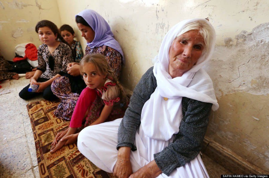 A Yazidi family who fled violence in the northern Iraqi town of Sinjar sit at at a school where they are taking shelter in the Kurdish city of Dohuk in Iraq's autonomous Kurdistan region, on August 5, 2014. (SAFIN HAMED/AFP/Getty Images)