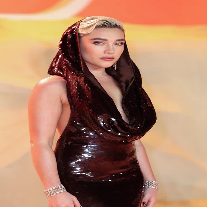 Florence Pugh in a sequined hooded gown at a premiere, paired with slicked-back hair and a bracelet
