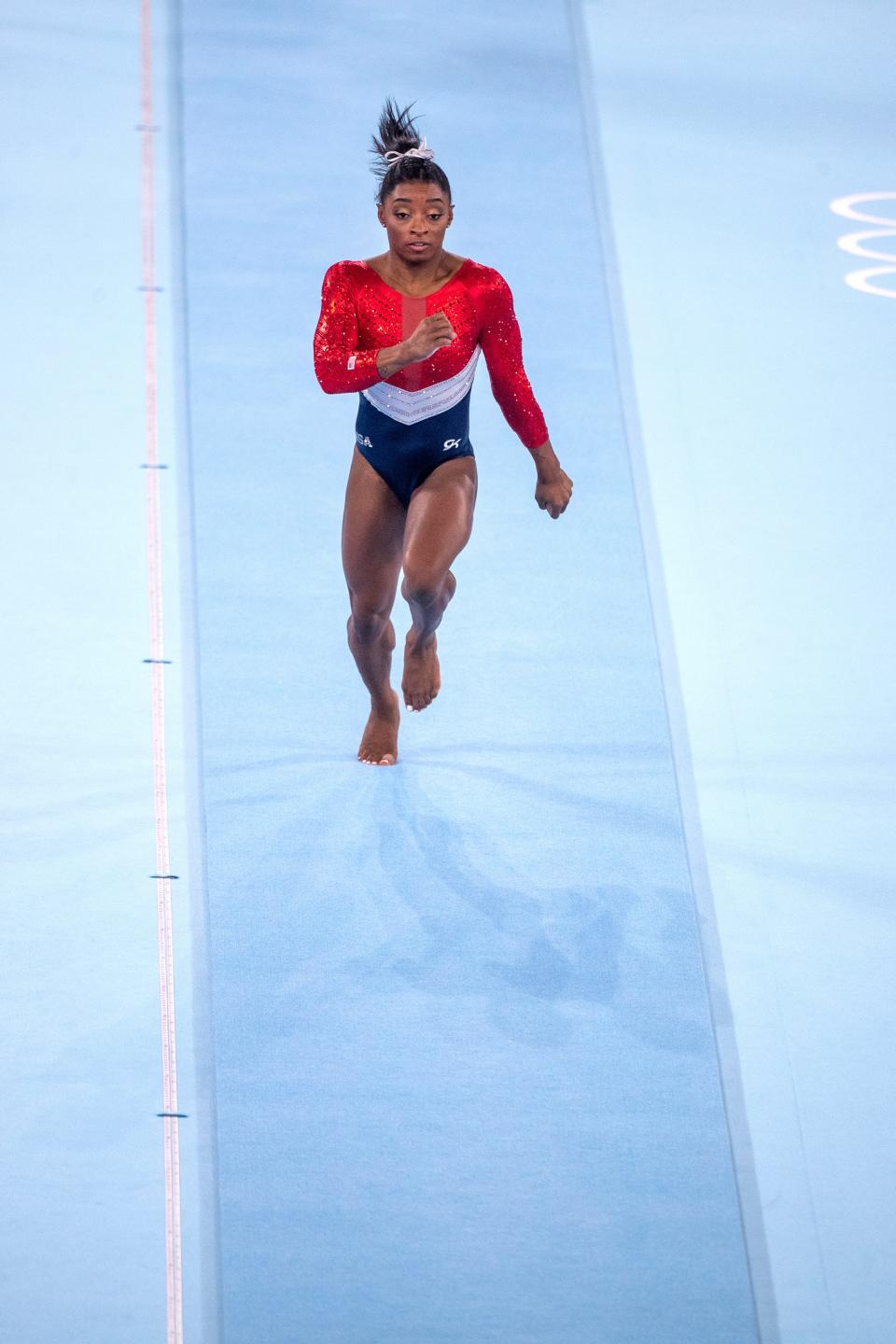 Biles is seen running toward the vault, which is not in view.