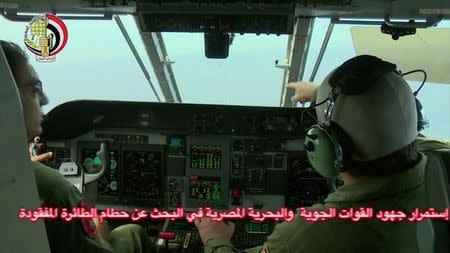 An Egyptian pilot (R) points during a search operation by Egyptian air and navy forces for the EgyptAir plane that disappeared in the Mediterranean Sea, in this still image taken from video May 20, 2016. Egyptian Military/Handout via Reuters TV