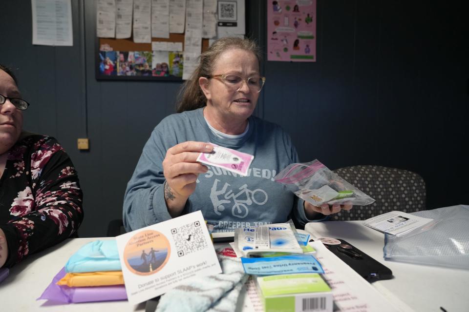 Stephanie Rosenwinge, a co-founder of SLAAP, sifts through items in a patient care package. Along with medical necessities, the package contains a handwritten note of support signed by the organization's members.