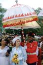 <p>In a blue and white striped dress with a matching hat, the queen carried a bouquet of yellow flowers when she visited the Peradeniya Gardens in Sri Lanka.</p>