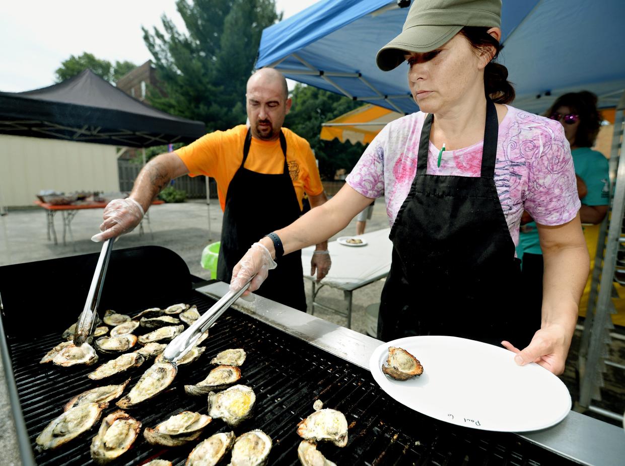 Karen Conn, right, and Justin Right of Conn's Hospitality Group grill oysters at the Springfield Oyster and Beer Festival at Inn at 835 in Springfield Saturday Sept. 3, 2022.