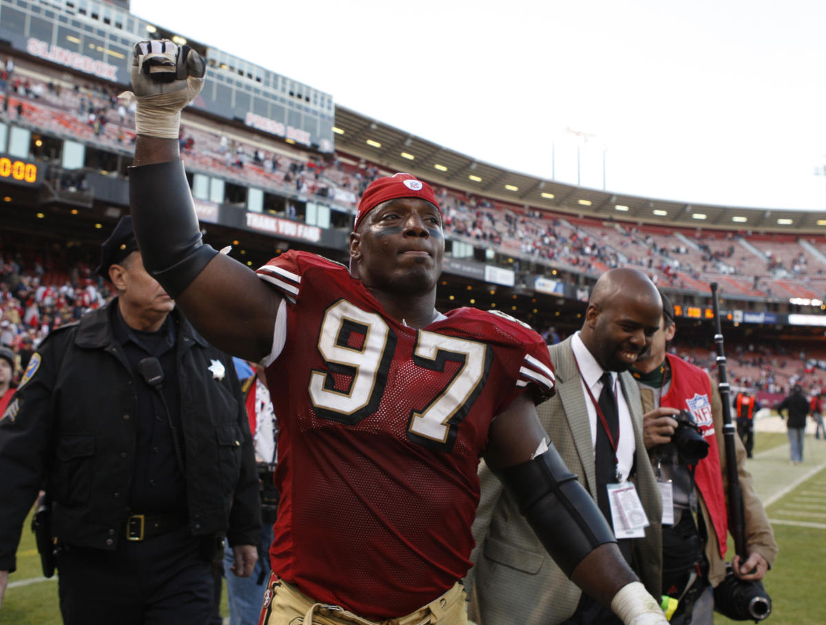 Former NFL player Bryant Young poses with his bust during an