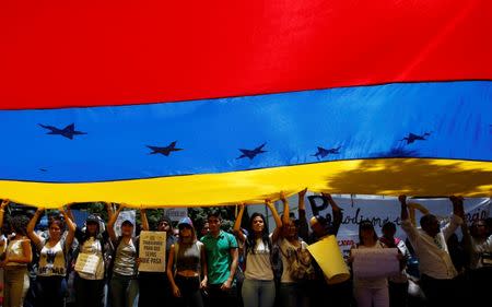 Demonstrators holding a Venezuelan flag attend a rally against Venezuela's President Nicolas Maduro's government in Caracas, Venezuela June 27, 2017. REUTERS/Ivan Alvarado
