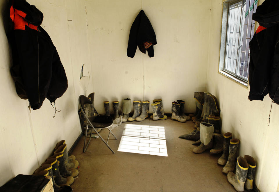 In this Sept. 25, 2012 photo, the jackets and boots of mine workers from the National Copper Mine Corporation, or Codelco, sit in a room outside a tunnel drilled under the Chuquicamata copper mine in the Atacama desert in northern Chile. Experts say that by 2019 the Chuquicamata copper mine will be unprofitable, so state-owned mining company Codelco is trying to head off closure by converting the open pit into the world's largest underground mine. Codelco believes the mine still has much more to give, with reserves equal to about 60 percent of all the copper exploited in the mine's history still buried deep beneath the crater. (AP Photo/Jorge Saenz)