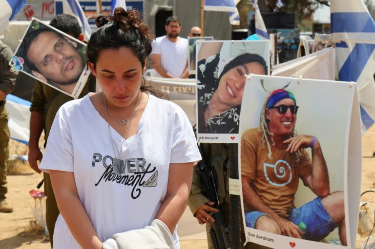 Israeli mourners observe two minutes of silence on Memorial Day, among portraits of hostages held by Hamas militants in Gaza (JACK GUEZ)