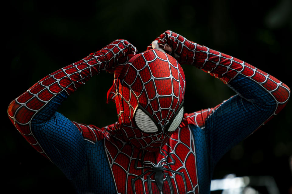 A member of the "Desliga da Justica" street band gets dressed in his spiderman costume in Rio de Janeiro, Brazil, Sunday, Feb. 14, 2021. The group's performance was broadcast live on social media for those who were unable to participate in the carnival due to COVID restrictions after the city's government officially suspended Carnival and banned street parades or clandestine parties. (AP Photo/Bruna Prado)