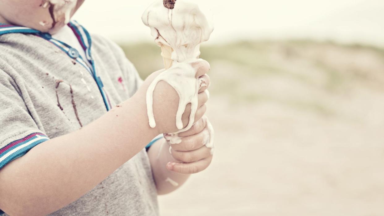 child eating melted ice cream