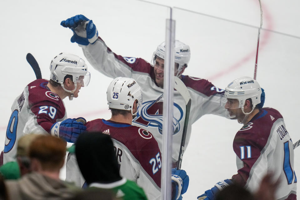 Colorado Avalanche center Nathan MacKinnon, left, celebrates with teammates Logan O'Connor (25), Miles Wood (28) and Andrew Cogliano (11) after scoring the game-winning goal against the Dallas Stars during overtime of an NHL hockey game, Thursday, Jan. 4, 2024 in Dallas. The Avalanche won 5-4. (AP Photo/Julio Cortez)