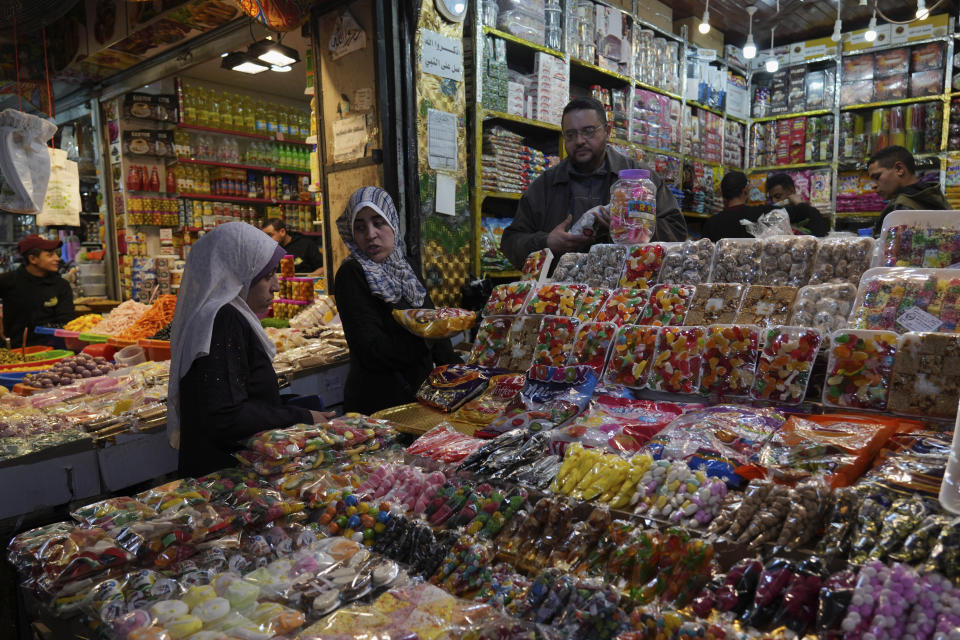 Women shop sweets for the Muslim holy month of Ramadan, at al-Zawya traditional market in Gaza City, Thursday, March 31, 2022. As Ramadan begins with the new moon next week, Muslims around the world are trying to maintain their religious rituals of Islamic holiest month. (AP Photo/Adel Hana)