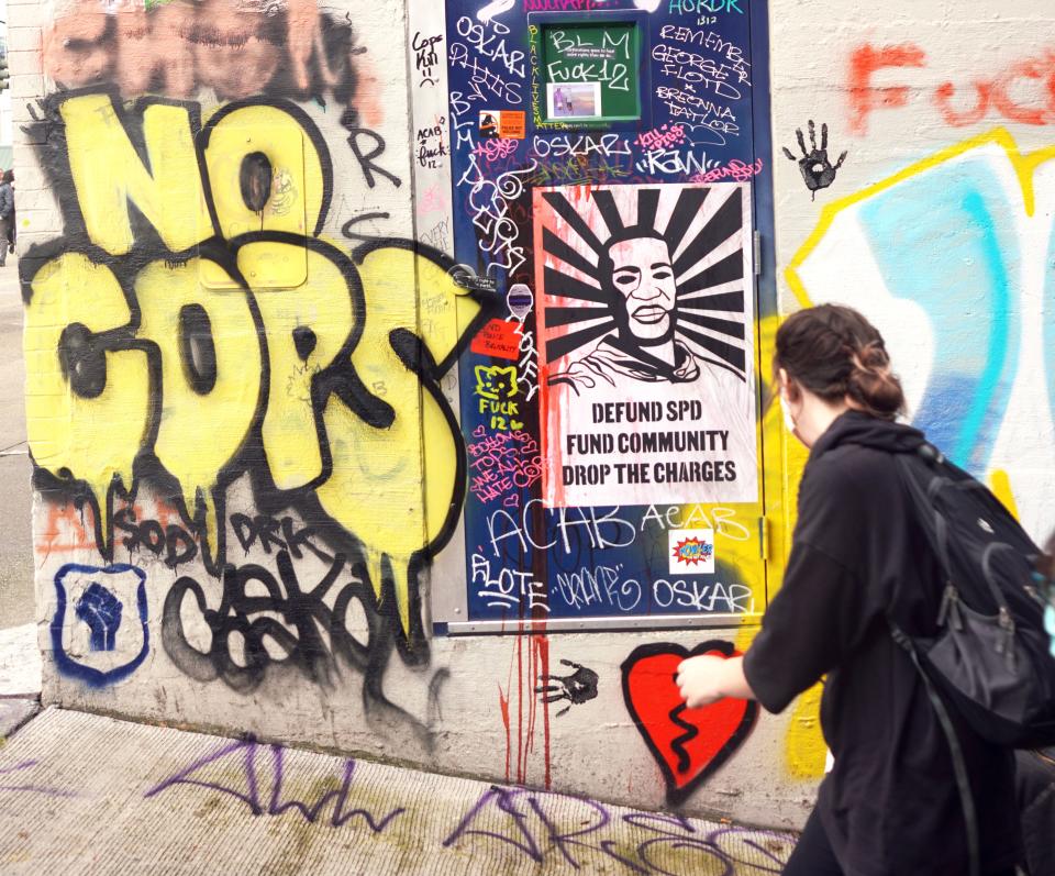 A person walks past a mural honoring George Floyd in the Capitol Hill Autonomous Zone in Seattle.