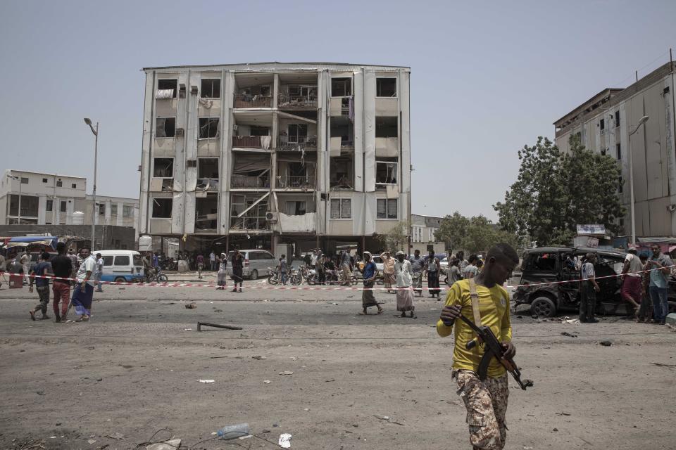 Civilians and security forces gather at the site of a deadly attack on the Sheikh Othman police station, in Aden, Yemen, Thursday, Aug. 1, 2019. Yemen's rebels fired a ballistic missile at a military parade Thursday in the southern port city of Aden as coordinated suicide bombings targeted the police station in another part of the city. The attacks killed over 50 people and wounded dozens. (AP Photo/Nariman El-Mofty)