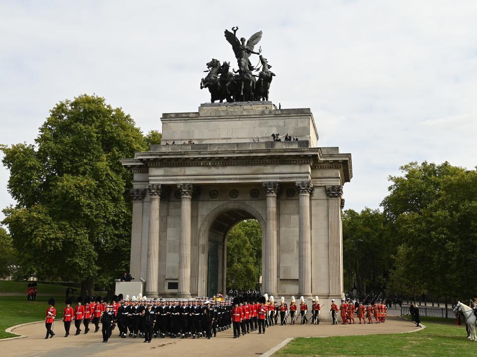 The coffin of Queen Elizabeth II with the Imperial State Crown resting on top, borne on the State Gun Carriage of the Royal Navy followed by members of the royal family proceeds past The Wellington Arch on September 19, 2022 in London, England.