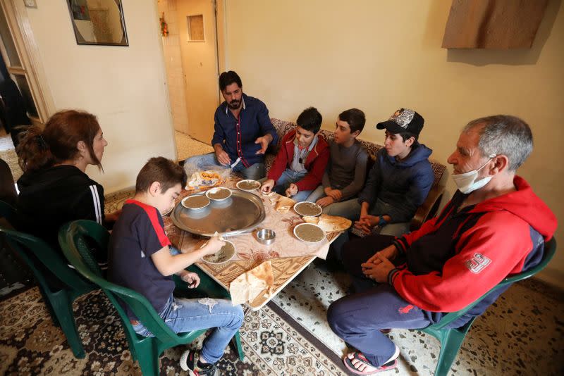 Hassan Zeitar, 39, eats with his family inside his home in Choueifat