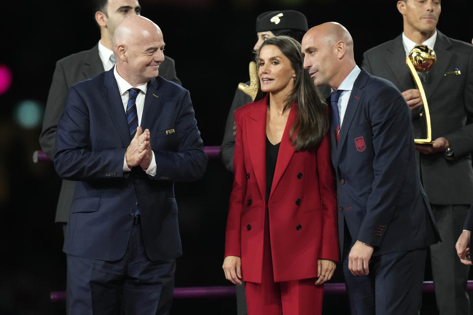 From left, FIFA President Gianni Infantino, Queen Letizia and President of Spain's soccer federation, Luis Rubiales, talk on the podium following Spain's win in the final of Women's World Cup soccer against England at Stadium Australia in Sydney, Australia, Sunday, Aug. 20, 2023. (AP Photo/Alessandra Tarantino)