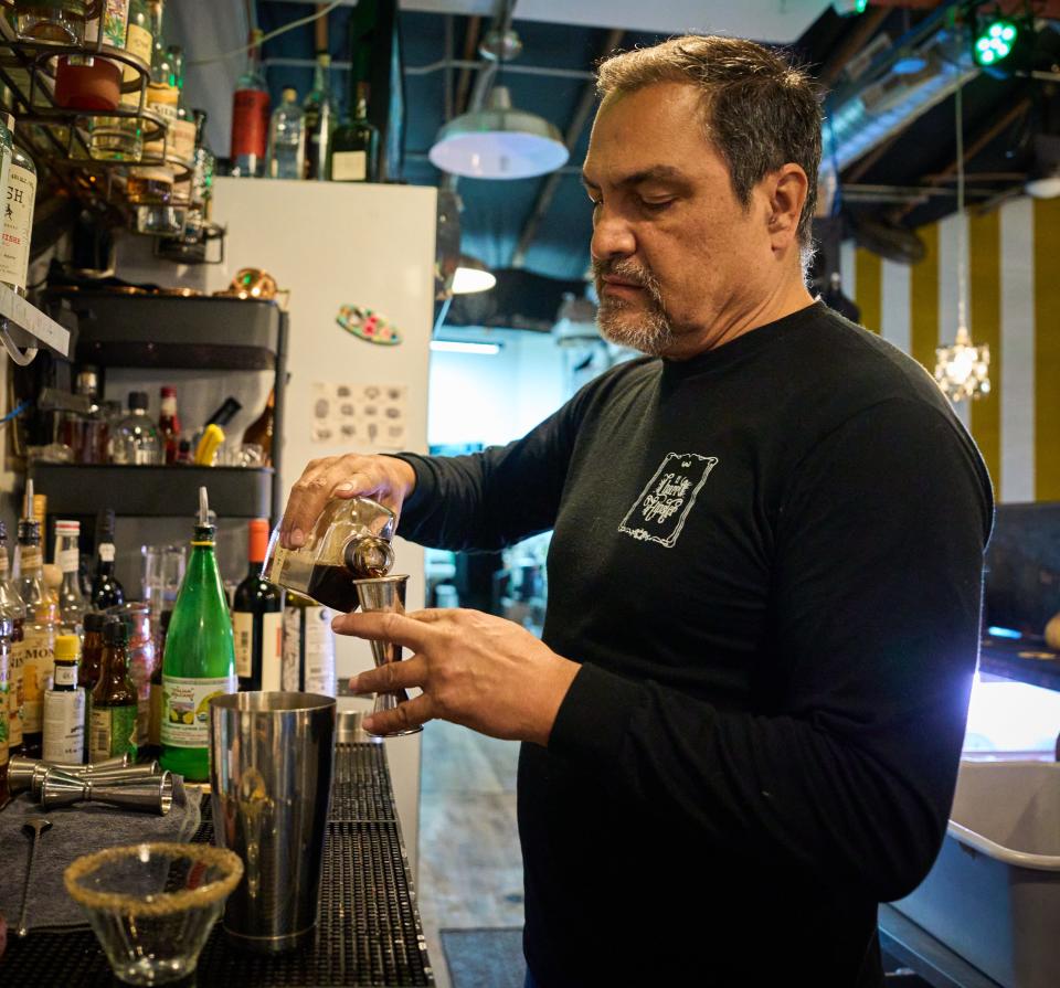 Francisco Peralta pours Mr. Black Coffee Liqueur into a double jigger while preparing an espresso agave martini at El Charro Hipster Bar and Cafe in Phoenix on Jan. 28, 2023.