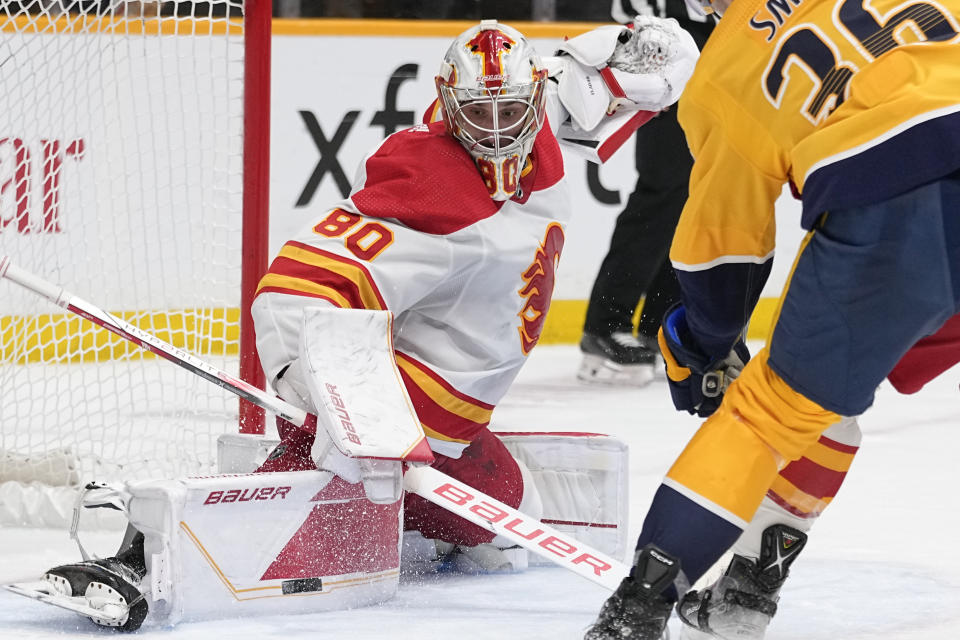 Calgary Flames goaltender Dan Vladar (80) blocks a shot on goal during the second period of an NHL hockey game against the Nashville Predators, Thursday, Jan. 4, 2024, in Nashville, Tenn. (AP Photo/George Walker IV)