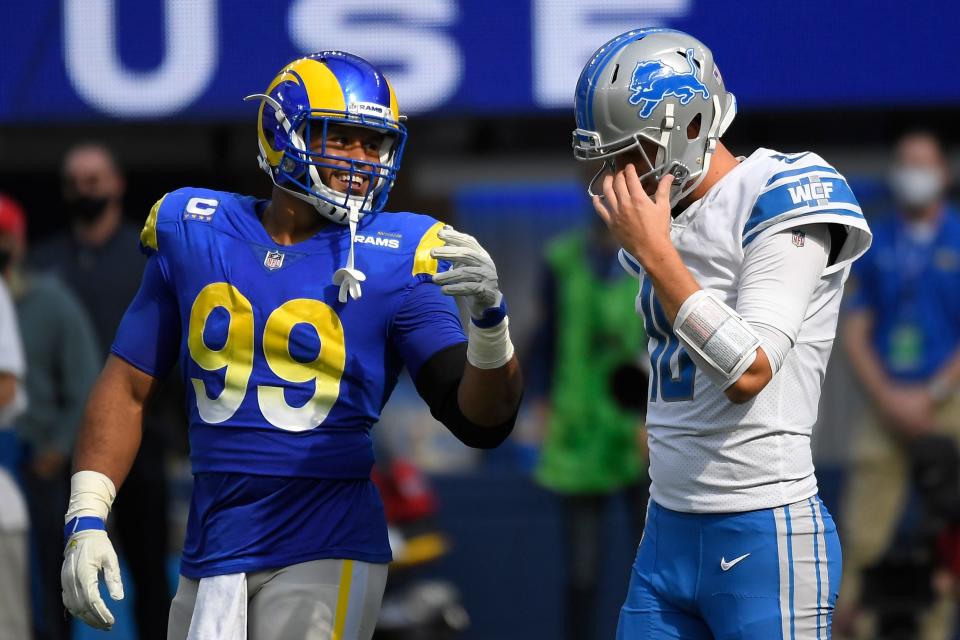 Lions quarterback Jared Goff talks with Rams defensive end Aaron Donald during the first half Sunday.