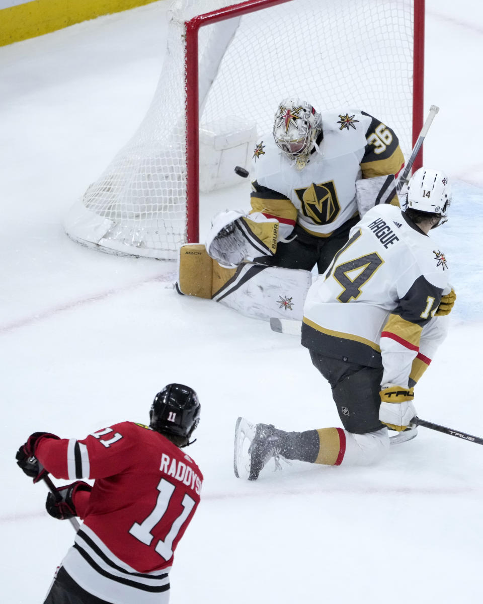 Chicago Blackhawks' Taylor Raddysh watches his shot score past Vegas Golden Knights goaltender Logan Thompson as Brayden Pachal also defends during the third period of an NHL hockey game Thursday, Dec. 15, 2022, in Chicago. The Golden Knights won 4-1. (AP Photo/Charles Rex Arbogast)