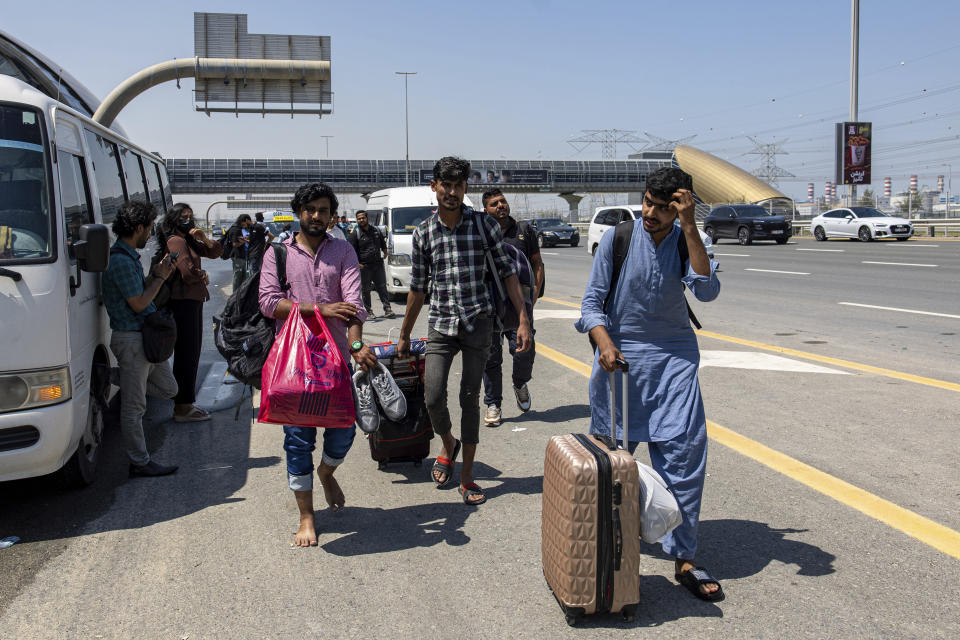 People wait for transportation on Sheikh Zayed Road highway in Dubai, United Arab Emirates, Thursday, April 18, 2024. The United Arab Emirates attempted to dry out Thursday from the heaviest rain the desert nation has ever recorded, a deluge that flooded out Dubai International Airport and disrupted flights through the world's busiest airfield for international travel. (AP Photo/Christopher Pike)