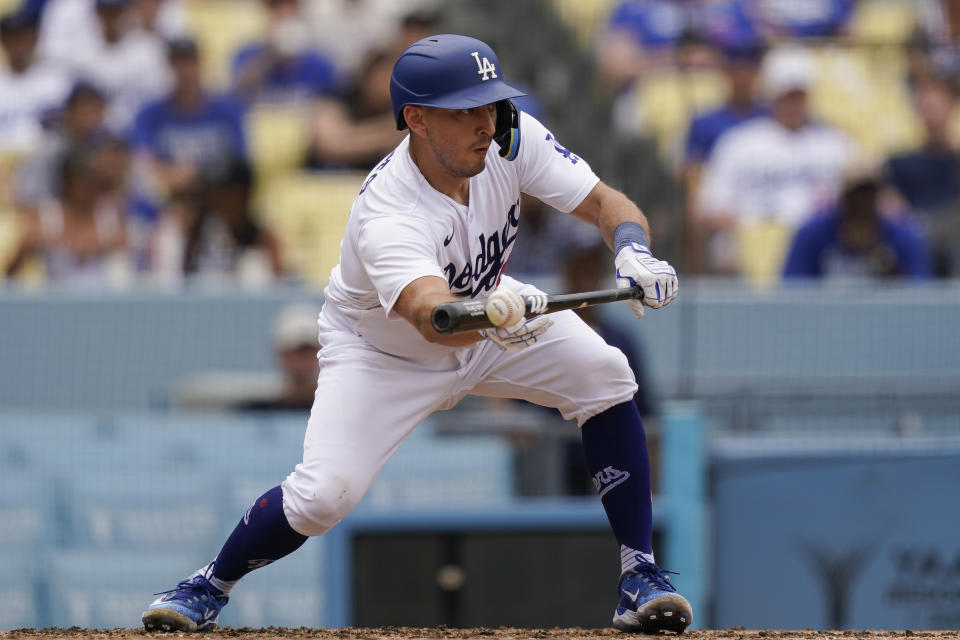 Los Angeles Dodgers' Austin Barnes bunts the ball leading to James Outman to score off of a throwing error by Miami Marlins first baseman Josh Bell during the eighth inning in the first baseball game of a doubleheader, Saturday, Aug. 19, 2023, in Los Angeles. (AP Photo/Ryan Sun)