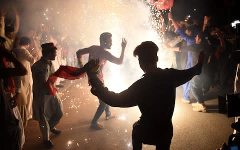 Supporters of Pakistan's cricketer-turned politician Imran Khan, and head of the Pakistan Tehreek-e-Insaf (Movement for Justice) party, celebrating in Karachi on Thursday after the election - Credit: AFP