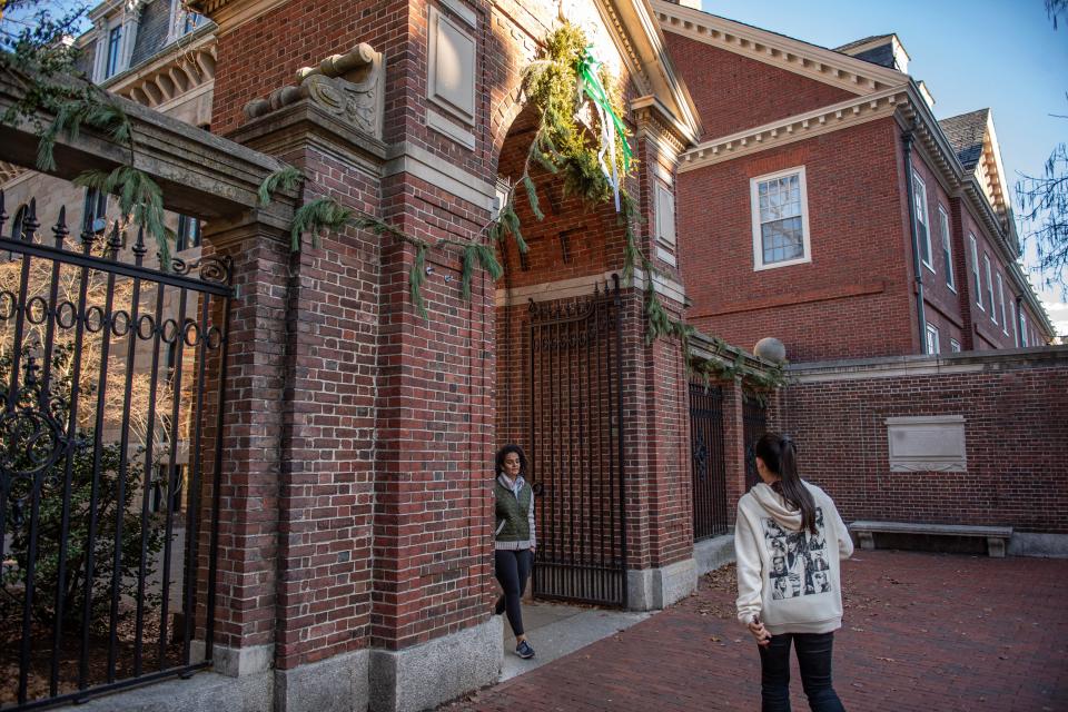 People enter and exit Harvard Yard at a gate at Harvard University in Cambridge, Massachusetts on December 12, 2023.