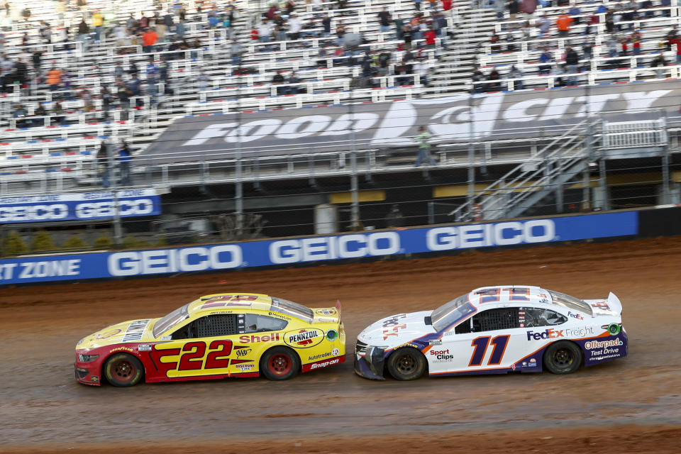 Driver Joey Logano (22) leads Denny Hamlin (11) through Turn 4 during an NASCAR Cup Series auto race, Monday, March 29, 2021, in Bristol, Tenn. (AP Photo/Wade Payne)