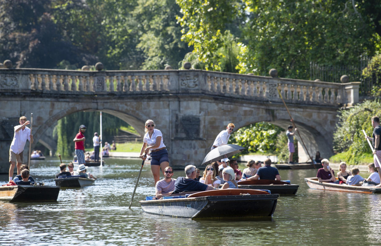 People punt along the River Cam in Cambridge, England, Sunday Aug. 25, 2019, as the hot weather continues throughout the weekend. (Joe Giddens/PA via AP)