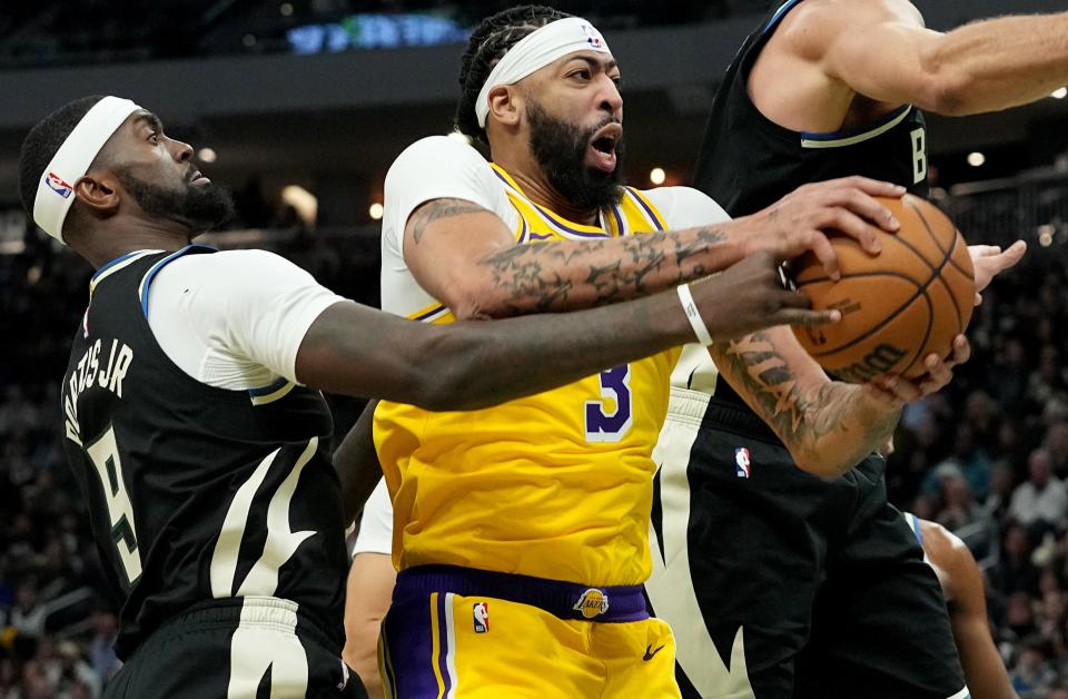 Milwaukee Bucks forward Bobby Portis fouls Los Angeles Lakers forward Anthony Davis during the first half Tuesday. Davis played a game-high 52 minutes and scored 34 points and had 23 rebounds in the Lakers' comeback double-overtime victory.