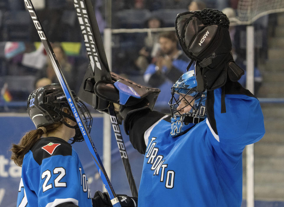 Toronto goaltender Kristen Campbell (50) celebrates clinching first place in the league with teammate Maggie Connors (22) after defeating Minnesota in a PWHL hockey game in Toronto on Wednesday, May 1, 2024. (Frank Gunn/The Canadian Press via AP)