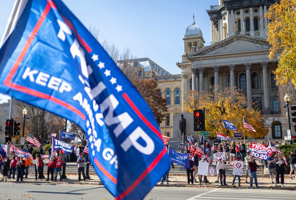 Supporters of President Donald Trump hold up signs with "Stop the Steal" during a rally in front of the Abraham Lincoln statue at the Illinois State Capitol, Saturday, November 7, 2020, in Springfield, Ill.
