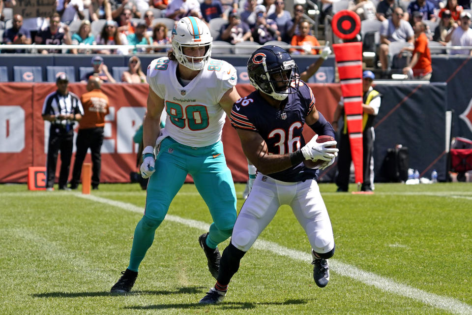Chicago Bears defensive back DeAndre Houston-Carson, right, runs with the ball after he intercepts a pass against Miami Dolphins tight end Adam Shaheen during the first half of an NFL preseason football game in Chicago, Saturday, Aug. 14, 2021. (AP Photo/Nam Y. Huh)