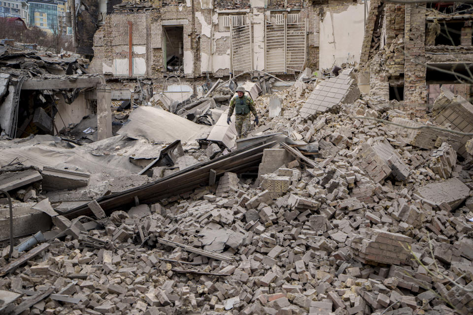 A Ukrainian serviceman inspects the damage to a building at the Pecherskyi district, after a Russian air attack in Kyiv, Ukraine, Monday March 25, 2024. (AP Photo/Vadim Ghirda)