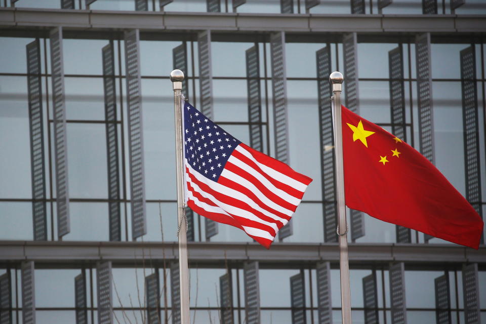 Chinese and U.S. flags flutter outside the building of an American company in Beijing, China, January 21, 2021. REUTERS/Tingshu Wang
