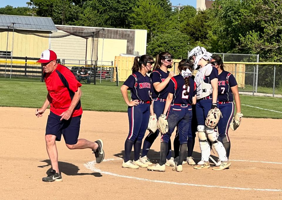 Belvidere North head coach Brian Hilden, left, runs back to the dugout after talking to his pitcher Becca Schwartz and the rest of the infield at Sycamore on Wednesday, June 1, 2022. The Blue Thunder went on to beat Woodstock North 5-4 to advance to the sectional finals.