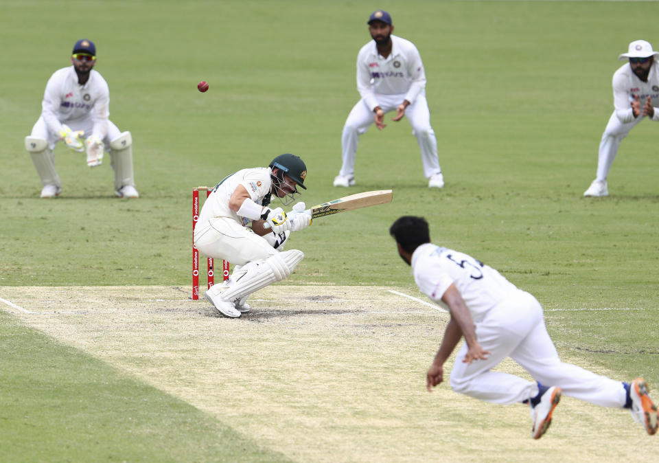 Australia's David Warner ducks to avoid bouncer from India's Shardul Thakur during play on day four of the fourth cricket test between India and Australia at the Gabba, Brisbane, Australia, Monday, Jan. 18, 2021. (AP Photo/Tertius Pickard)