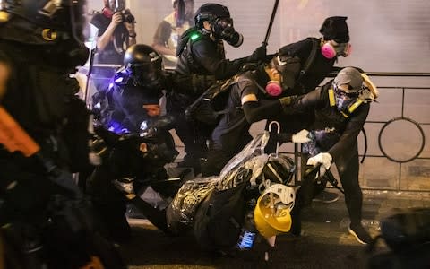 Members of the police force's Special Tactical Squad clash with demonstrators on Des Voeux Road West during a protest in the Sheung Wan - Credit: Bloomberg