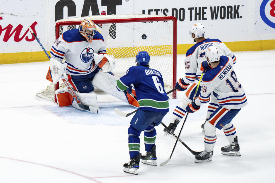 Edmonton Oilers goalie Stuart Skinner gives up a goal to Vancouver Canucks' Nikita Zadorov, not seen, as Oilers' Darnell Nurse, back right, and Adam Henrique, front right, and Canucks' Brock Boeser watch during the second period of Game 2 of an NHL hockey Stanley Cup second-round playoff series, Friday, May 10, 2024, in Vancouver, British Columbia. (Ethan Cairns/The Canadian Press via AP)