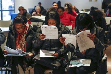 People fill out application forms before a screening session for seasonal jobs at Coney Island in the Brooklyn borough of New York March 4, 2014. REUTERS/Shannon Stapleton