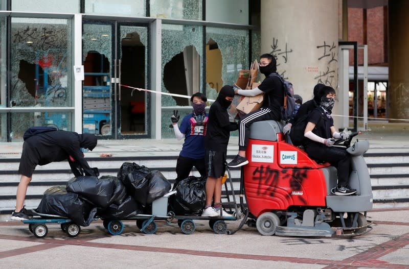 Protesters transport supplies on a road sweeper outside the Polytechnic University in Hong Kong