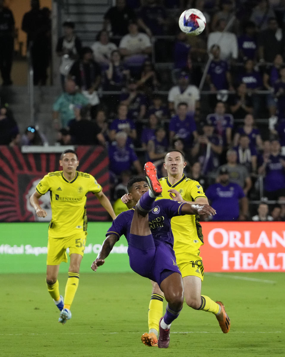 Orlando City midfielder Wilder Cartagena, center, clears the ball from Nashville SC midfielder Alex Muyl (19) and defender Jack Maher (5) during the first half of an MLS playoff soccer match, Monday, Oct. 30, 2023, in Orlando, Fla. (AP Photo/John Raoux)