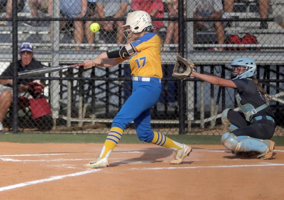 Fort Mill’s Sydnie Spears hits the ball as Dorman’s Emma Bright tries to catch it.