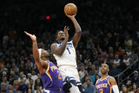 Minnesota Timberwolves guard Anthony Edwards (1) drives past Phoenix Suns forward Josh Okogie (2) as Suns guard Chris Paul, right, looks on during the first half of an NBA basketball game Wednesday, March 29, 2023, in Phoenix. (AP Photo/Ross D. Franklin)