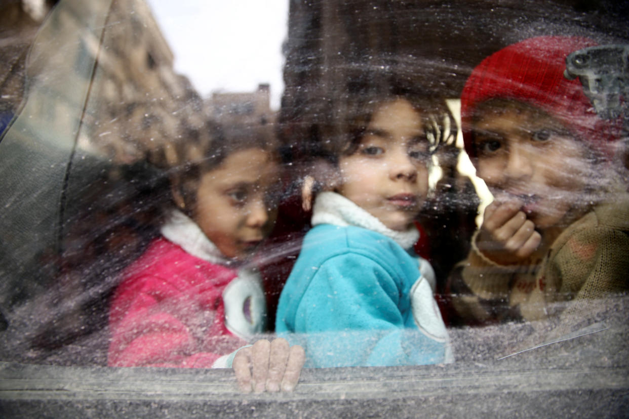 Children look through a bus window during an evacuation from the besieged town of Douma, in Syria's eastern Ghouta region, on March 13, 2018.&nbsp; (Photo: Bassam Khabieh/Reuters)